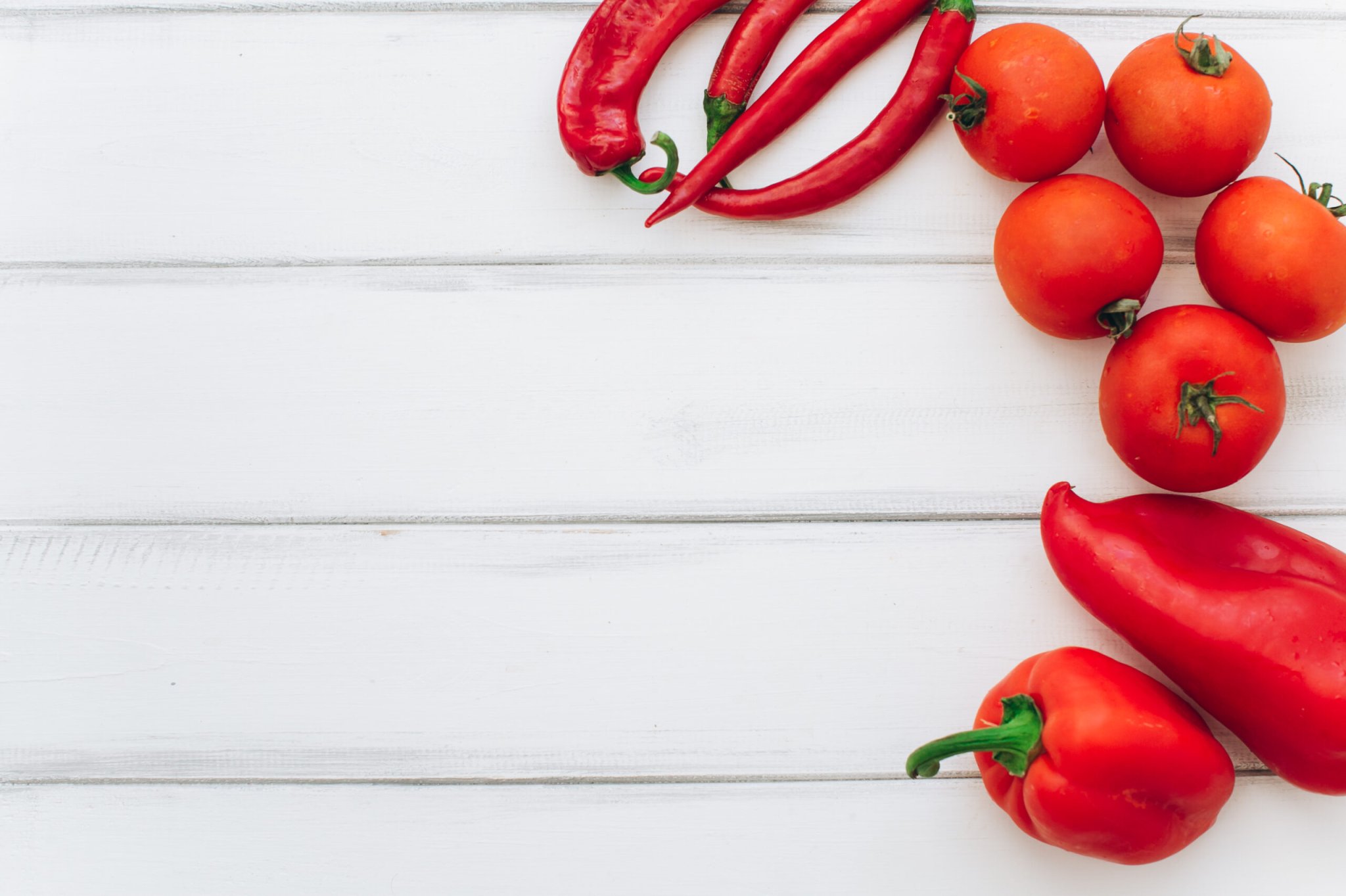 tomatoes and red peppers on a white table