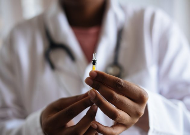 person holding vaccine syringe