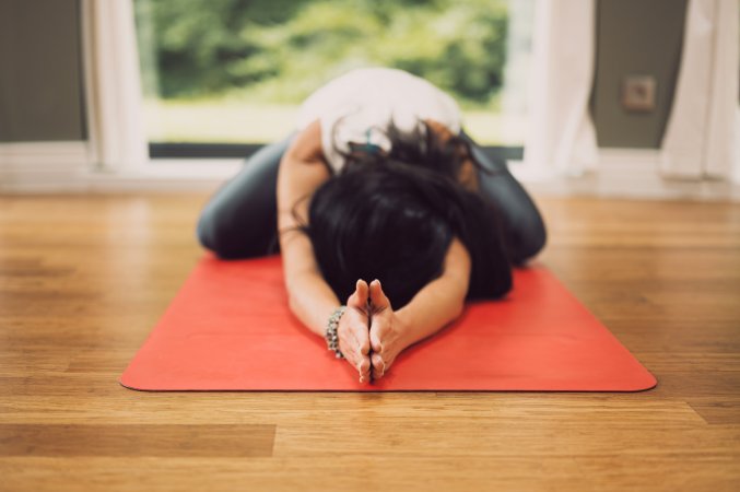 a woman in child's pose, which is a basic stretch