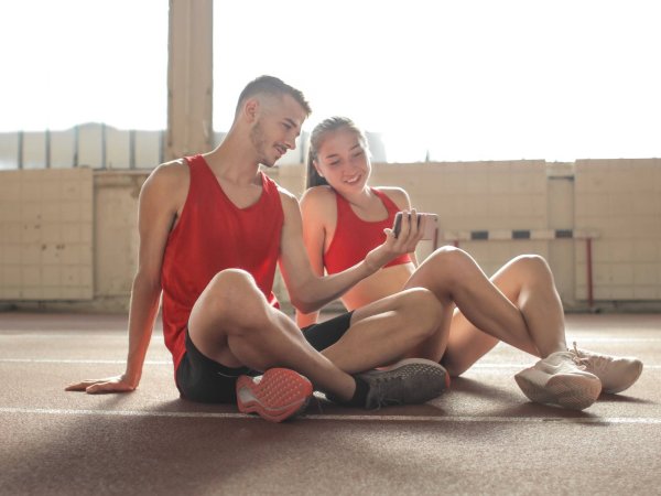 People looking at smartphone and working out