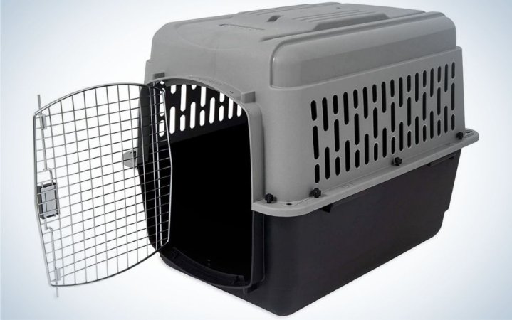 An animal cage which is made of rubber and has an open door and has black and dark gray colors.