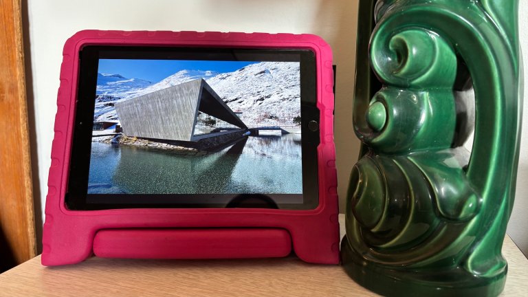 an ipad with a photo on it next to a lamp
